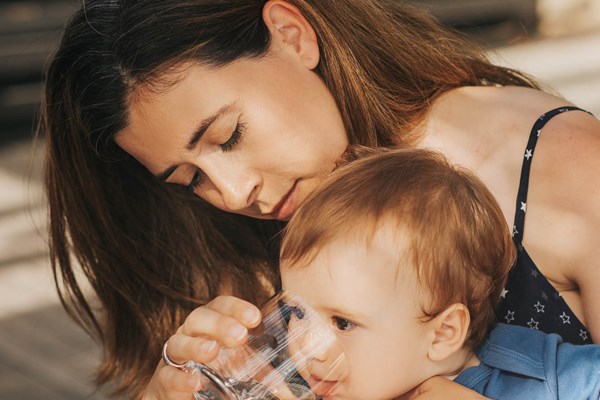 mother giving toddler water