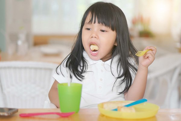 Little girl with a mouthful of food