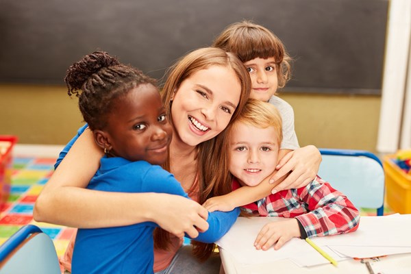 Young carer hugging children