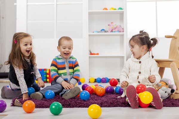 Young children playing with balls in a nursery
